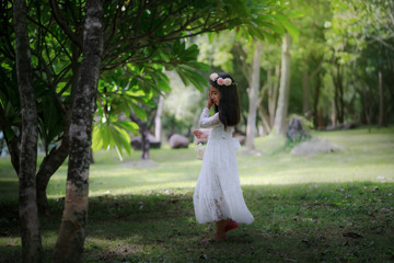 Portrait of little Asian girl walking in  the nature forest with soft tone processed