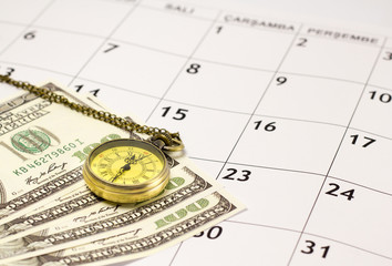 Pocket Watch and dollar bills over the calendar