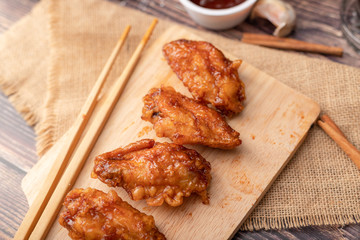 Hot and spicy Korean barbeque fried chicken on wood cutting board
