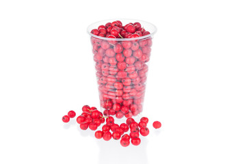 Ripe rowan berries in plastic cup on white background