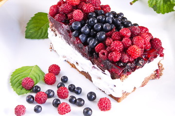 Cake with cream and fresh raspberries and blueberries useful delicacy