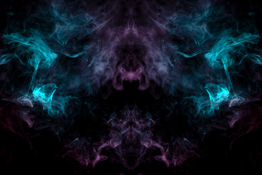 A mystical image of a large face of a creature or ghost with eyes and cheekbones of green and pink smoke on a black isolated background. Print for clothes.