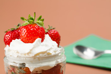 Fresh strawberries and cream served in a bowl in a macro shot