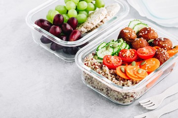 Meal prep lunch box containers with quinoa, meatballs cucumbers, carrots and pumpkin seeds