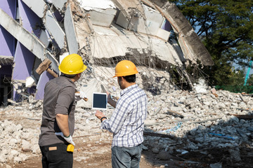 Demolition control supervisor and contractor discussing on demolish building.
