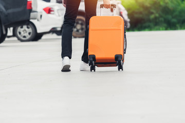 Woman tourist with orange suitcase at station background. travel, tourist, vacation concept.