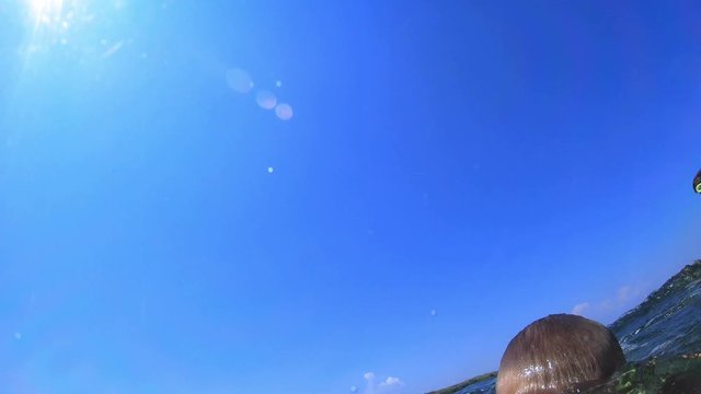 Young Handsome Boy Jumping to the Sea. Children jump into the sea of somersaults. Teenagers jump into the water. Swim under water and play. Summer fun at sea. Slow-motion