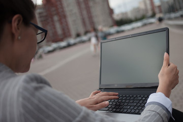 Young ambitious woman with a laptopworks on a laptop during a break.