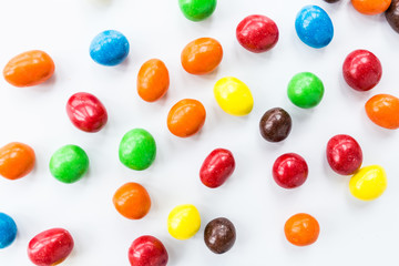 Candy lying on white background. Bright and Colorful sweets top view. Flat lay image. Copy space template. Unhealthy eating concept