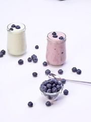 Fresh blueberry yogurt glass on a white background