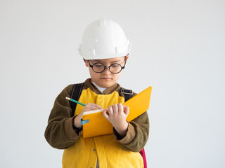 Asian boy with white engineer hat and whiting on the book education concept