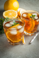 Glasses of cold ice tea with lemon, ice, mint on background. Homemade lemonade. Spring and summer drinks and beverages concept.