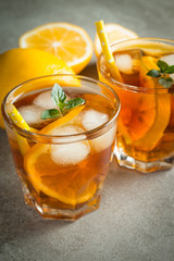 Glasses of cold ice tea with lemon, ice, mint on background. Homemade lemonade. Spring and summer drinks and beverages concept.