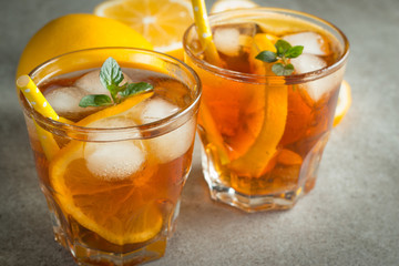 Glasses of cold ice tea with lemon, ice, mint on background. Homemade lemonade. Spring and summer drinks and beverages concept.