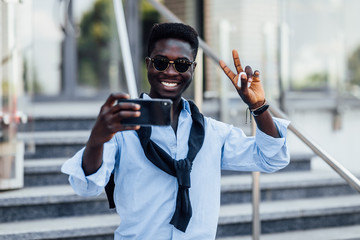 Handsome African tourist male making selfie by phone in the street. Lifestyle.