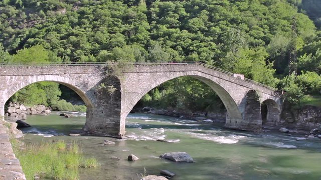 The medieval stone bridge of Echallod in Arnad, over the river dora baltea in Aosta Valley//Italy.It is a path of the famous way francigena is in Romanesque style in shape of a donkey's back
