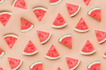 Creative flat lay top view of fresh watermelon slices on orange table background with copy space. Minimal summer fruits pattern for blog or recipe book. Healthy food and diet concept.