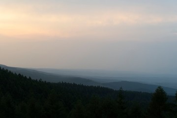 山に霧が掛かり森がシルエットになった夕焼けの風景／Nagano, Japan