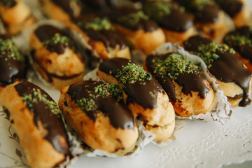 Traditional sweet french eclair or profiterole desserts on the table. 
