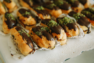 Traditional sweet french eclair or profiterole desserts on the table. 