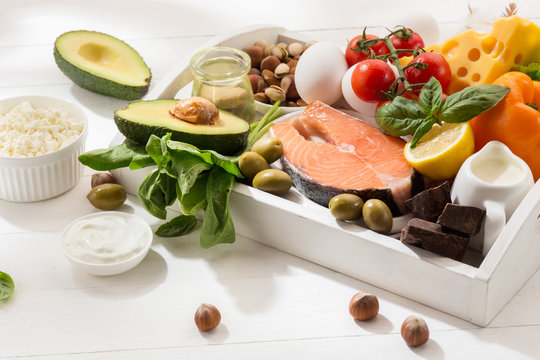 Ketogenic low carbs diet - food selection on white wooden background. Balanced healthy organic ingredients of high content of fats. Nutrition for the heart and blood vessels. Meat, fish and vegetables