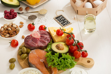 Ketogenic low carbs diet - food selection on white wooden background. Balanced healthy organic ingredients of high content of fats. Nutrition for the heart and blood vessels. Meat, fish and vegetables