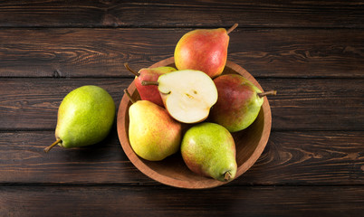 Pears in a plate on old wooden table.