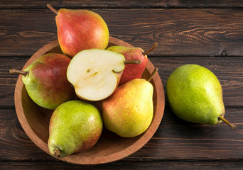 Pears in a plate on old wooden table.