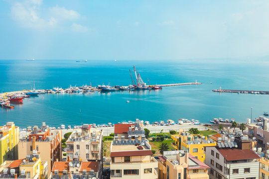 Industrial port or harbor with container or cargo ships and cranes in iskenderun seaport at Hatay city of Turkey. Transportation and logistic at Mediterranean sea. 