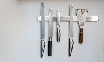 Magnetic wall installed knives holder for modern kitchen.