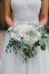 bride holding organic garden wedding flower bouquet with greenery 