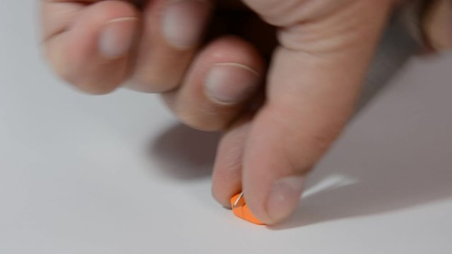 Dosing, halve orange pill  with a knife