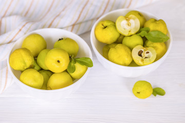 quince fruit in white cups on a white background close-up. background with ripe quince fruits on the table.