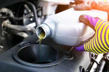 Change the Oil. Hand mechanic in repairing car. Close up oil for car engine. Motor oil pouring to...