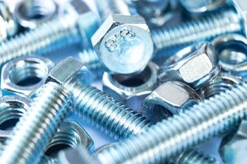 Metal bolts and nuts  in a row background. Chromed screw bolts and nuts isolated. Steel bolts and nuts pattern. Set of Nuts and bolts. Tools for work.