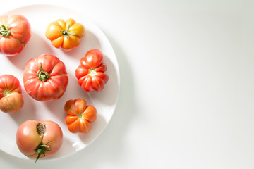 Ugly freak organic tomato on a white background. The concept of organic vegetables. The view from the top. Space for text.