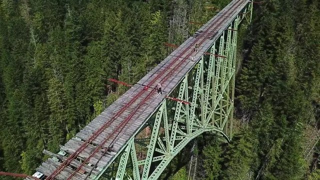 Vance Creek Bridge Orbit Aerial With Extreme Travelers Standing on Unsafe Railroad Over Deep Canyon, Washington State USA