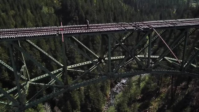 Extreme Traveler Walking on Abandoned Unsafe Vance Creek Bridge, Washington State USA. Slow Motion Aerial
