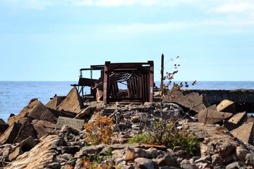 Obraz premium old abandoned pier on the beach with rusty metal structure