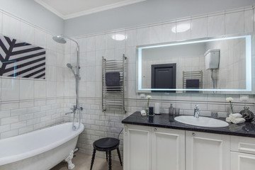 Luxury bright bathroom with sink, mirror and tub