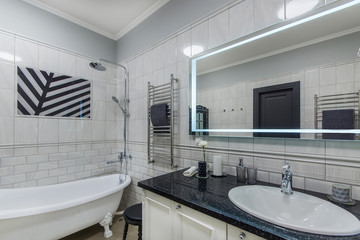 Luxury bright bathroom with sink, mirror and tub