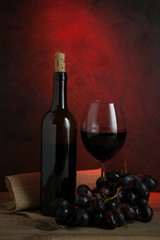 Botella con vino tinto y una copa con vino de Rioja