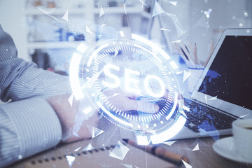 Double exposure of seo icon with man working on computer on background. Concept of search engine...