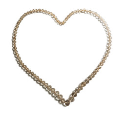 Vintage necklace of rock crystal laid out in a heart shape isolated on white