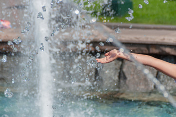 City fountain. Children's hand.