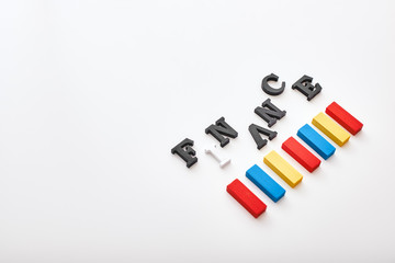Finance word created with cubes alphabet letters near multi-colored wooden blocks lying diagonally