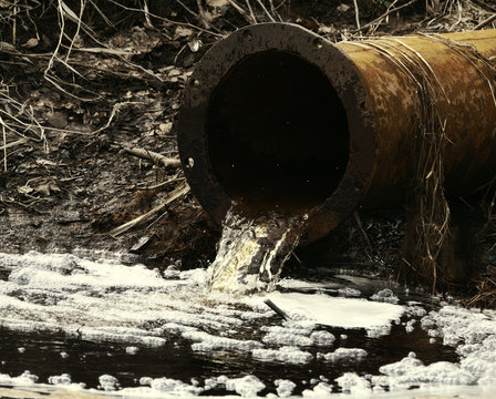 Dirty water flows out of old rusty pipe without cleaning