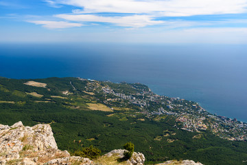 Fototapeta na wymiar view of the resort city of Yalta from the top of Mount Ai-Petri, on a bright sunny day with clouds in the sky.