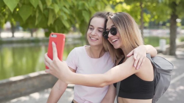 Two girls with sportswear and bikes taking selfies on the street
