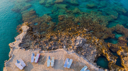 Chairs on Beach by Turquoise Water on Greek Island, Drone View
